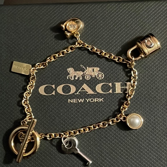Coach Accessories - Coach toggle two tone bracelet with 4 charms and a coach tag. Gold/silver.
